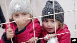 Syrian children wait to return to their country at the Turkish border crossing with Syria in the outskirts of Kilis, southeastern Turkey, Feb. 11, 2016. 