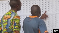 Des électeurs cherchent leurs noms avant d'aller voter dans un bureau à Yaoundé, Cameroun, le 30 septembre 2013.