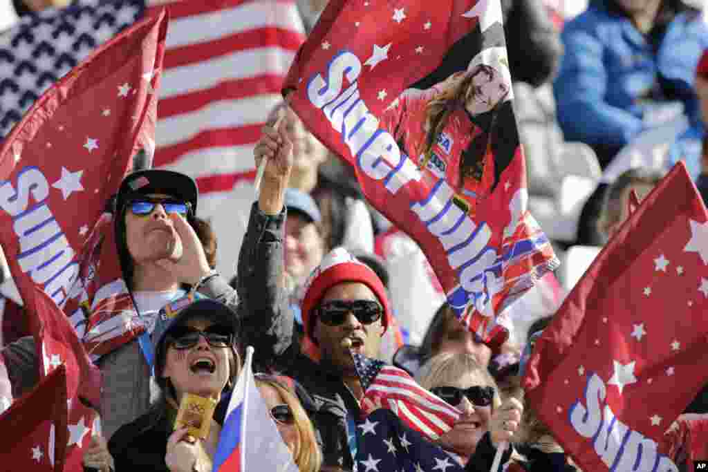 Fans wave flags for United States skier Julia Mancuso during the downhill portion of the women&#39;s supercombined,&nbsp;Krasnaya Polyana, Feb. 10, 2014.