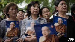 In this file photo, Thai women hold a portrait of Thai Supreme Patriarch Somdet Phra Nyanasamvara in Bangkok on October 25, 2013. 