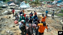 Tim penyelamat mengevakuasi korban dari reruntuhan gempa dan tsunami di Palu, Sulawesi Tengah (1/10).