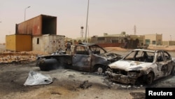 FILE - Vehicle wreckages are seen after a suicide car bomber blew himself at a checkpoint near Misrata, Libya, May 21, 2015.
