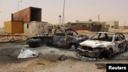 FILE - The wreckage of vehicles is seen after a suicide car bomber blew himself at a checkpoint near Misrata, Libya, May 21, 2015.