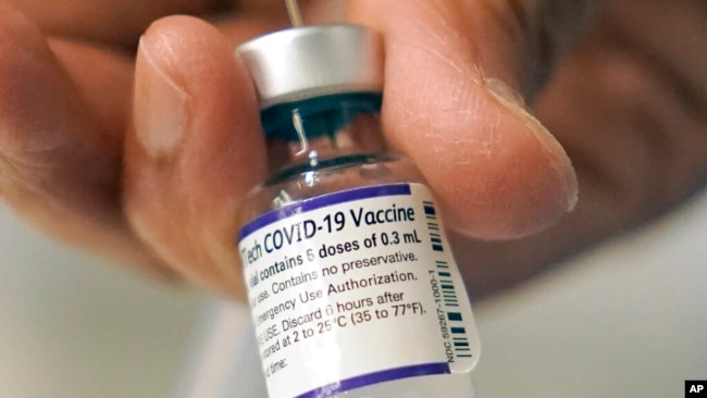 FILE - A doctor loads a dose of Pfizer COVID-19 vaccine into a syringe, Dec. 2, 2021, at a mobile vaccination clinic in Worcester, Mass. The Pfizer-BioNTech vaccine is the sole option for children in the U.S.