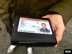 Nabil, a Tunisian who moved to St. Petersburg after terrorist attacks destroyed the Tunisian tourism industry, holds his 6 month temporary visa to Norway.