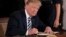 FILE - President Donald Trump signs an executive order in the East Room of the White House, in Washington, May 9, 2018.