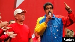 Venezuela's President Nicolas Maduro, right, speaks next to retired General Hugo Carvajal as they attend the Socialist party congress in Caracas, July 27, 2014. 