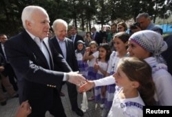 Les sénateurs McCain (à g.) et Lieberman saluent des enfants dans un camp de réfugiés près de la frontière turco-syrienne (10 avril 2012)