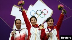 Para pemenang cabang olah raga menembak berpose seusai penerimaan medali mereka di hari pertama pelaksanaan Olimpiade London 2012. Dari kiri: Sylwia Bogacka (Polandia) peraih medali perak, Yi Siling (Tiongkok) peraih medali emas, dan Yu Dan (Tiongkok) pe