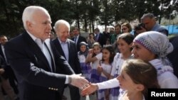 Les sénateurs McCain (à g.) et Lieberman saluent des enfants dans un camp de réfugiés près de la frontière turco-syrienne (10 avril 2012)