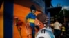 A soccer fan kisses a poster of Diego Maradona at the entrance of the Boca Juniors stadium, known as La Bombomera, in Buenos Aires, Argentina, Nov. 25, 2020. 