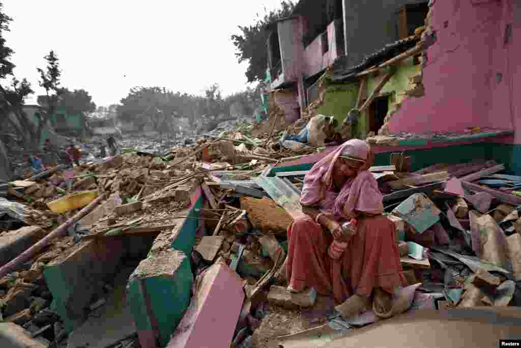 A woman reacts as her home was razed to the ground by local authorities in a bid to relocate the residents in a Delhi slum, India.