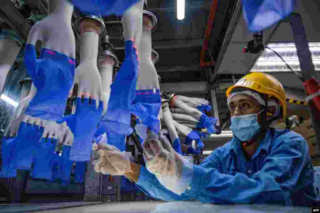 A worker inspects disposable gloves at the Top Glove factory in Shah Alam on the outskirts of Kuala Lumpur, Malaysia.