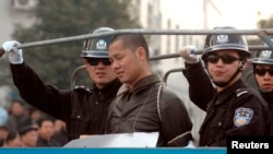 Một tội phạm bị kết án tử hình được đưa lên xe tải đến địa điểm hành quyết ở Hồ Nam, Trung Quốc. 