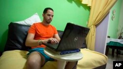 FILE - Cuban Roberto Carlos Villamar uses his laptop on a new experimental internet in the living room of his home in Havana, Cuba, Jan. 6, 2017.