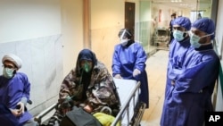 FILE - In this March 7, 2020 file photo, a patient infected with the new coronavirus is moved, at Baqiyatallah Al'Azam Hospital that is affiliated to the Revolutionary Guard, in Tehran, Iran.