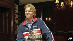 Two-time Davis Cup champion Jim Courier, who signed a multi-year agreement to lead the U.S. Davis Cup team, is shown with a replica of the Davis Cup after the United States Tennis Association made the announcement in New York, Oct 27, 2010