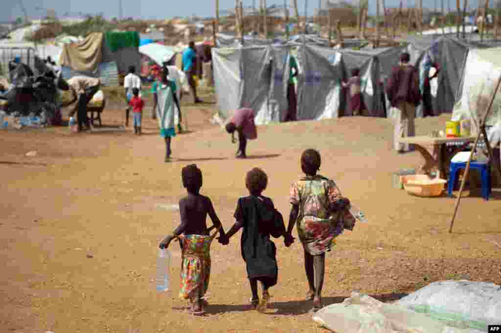 Three children walk through a spontaneous camp for internally displaced persons at the United Nations Mission to South Sudan (UNMISS) base in Juba, Jan. 9, 2014.