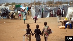 Three children walk through a spontaneous camp for internally displaced persons at the United Nations Mission to South Sudan (UNMISS) base in Juba, Jan. 9, 2014.