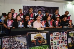 FILE - Relatives and supporters of victims of the 2009 Maguindanao massacre hold pictures of the victims during a press conference after the verdict in the case in Taguig, Manila, Dec. 9, 2019.