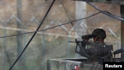 一名韩国士兵在朝韩边界非军事区的一个观察哨所用望远镜望向朝鲜方向。（资料照片）