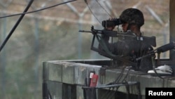 지난 4월 비무장지대 한국 측 초소에서 경계 근무 중인 군인이 망원경으로 북한 지역을 살피고 있다.