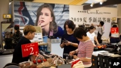 Shoppers browse at a discount retailer in a shopping mall in Beijing, Aug. 2, 2019. 
