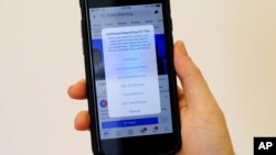 A smartphone display shows a Facebook notice that additional reporting is available on a doctored video posted last week showing House Speaker Nancy Pelosi appearing to slur her words, in San Francisco, May 28, 2019.