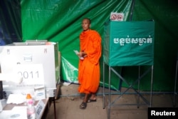 A monk votes at a polling station during a general election in Phnom Penh, Cambodia, July 29, 2018.
