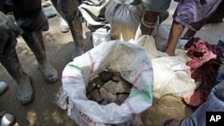 Des hommes debout autour d'un sac de cassitérite à Walikale, Congo (2010 (2010))