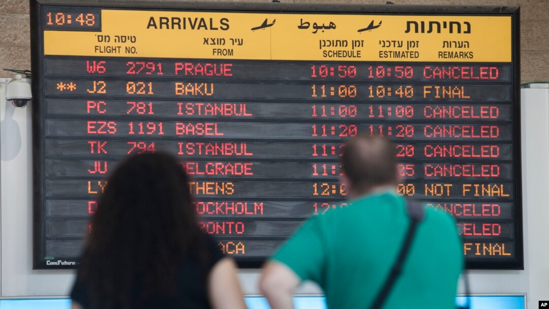 Para penumpang di bandara Ben Gurion, Tel Aviv melihat jadwal penerbangan (23/7). Maskapai AS dan Eropa membatalkan penerbangan ke bandara ini.