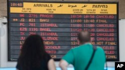 Para penumpang di bandara Ben Gurion, Tel Aviv melihat jadwal penerbangan (23/7). Maskapai AS dan Eropa membatalkan penerbangan ke bandara ini.