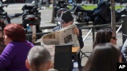 A man reads a newspaper in a terrace bar on what's called "The day of Reflection" before the general elections, in Madrid, April 27, 2019. Political parties give the public a rest day from their canvassing to relax and ponder before voting Sunday.