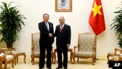 North Korean Foreign Minister Ri Yong Ho, left, poses with Vietnamese Prime Minister Nguyen Xuan Phuc for a photo during a meeting at the Government Office in Hanoi, Vietnam, Saturday, Dec. 1, 2018.