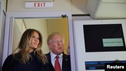 Rais Donald Trump (kulia) akiongea na waadishi wa habari waliokuwa ndani ya ndege ya rais. Pembeni ya Rais ni mkewe Melania.