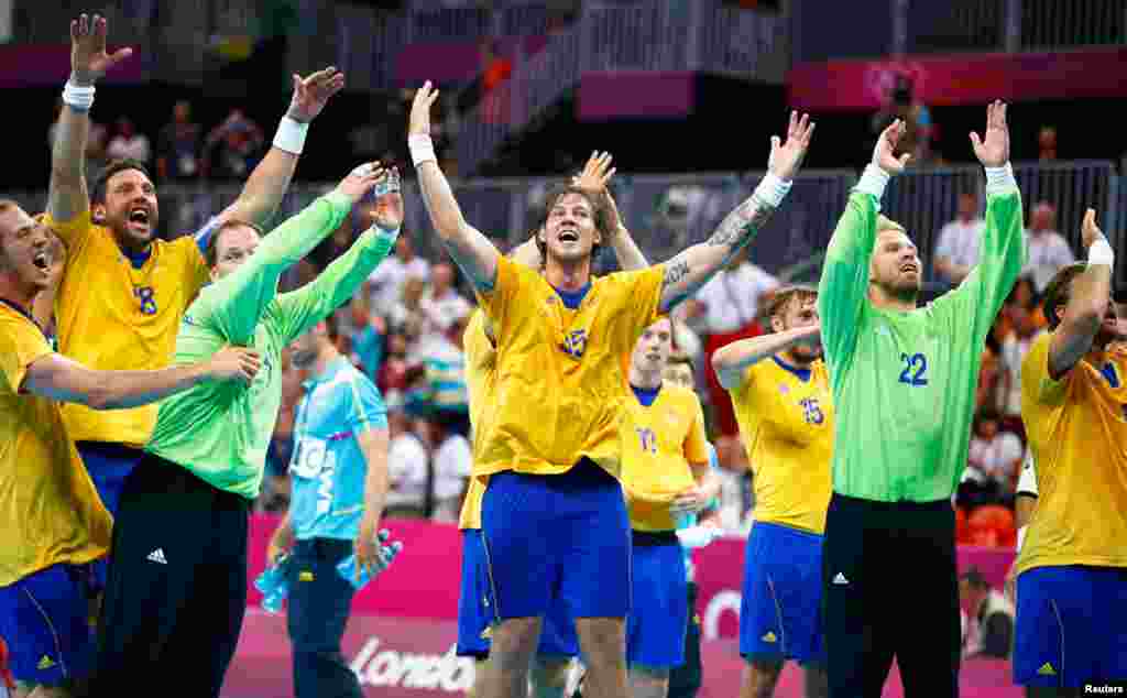Sweden's team players celebrate after defeating Hungary in their men's semi-final match at the Basketball Arena.