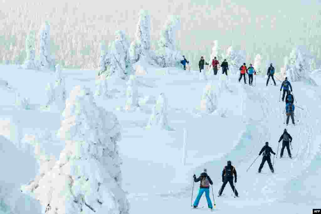 Cross-country skiers make their way through the snowy landscape on the Grosser Arber mountain in Bayerisch Eisenstein east of Regensburg, southern Germany.