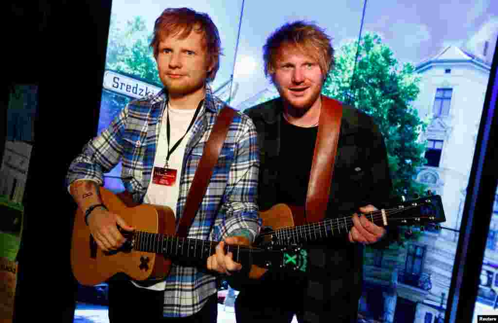 Nico Eckl (R), a lookalike of musician Ed Sheeran, poses next to a wax figure of the singer at Madame Tussauds wax museum in Berlin, Germany.