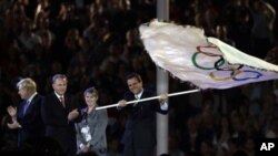12일 영국 런던에서 열린 올림픽 폐막식에서, 2016년 차기 올림픽 개최지인 브라질 리오데자네이루의 에두아르도 파에스 시장이 자크 로케 IOC 위원장으로부터 오륜기를 건네받고 있다.