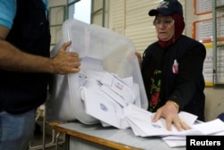 A Lebanese election official empties a ballot box after the polling station closed during Lebanon's parliamentary election, in Beirut, Lebanon, May 6, 2018.