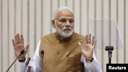 FILE - India's Prime Minister Narendra Modi gestures as he addresses the gathering during the 'Global Mobility Summit' in New Delhi, India, Sept. 7, 2018. 