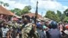 Security forces try to protect a Nigerian man accused of kidnapping a child from an angry crowd in Bissau, Oct. 8, 2013.