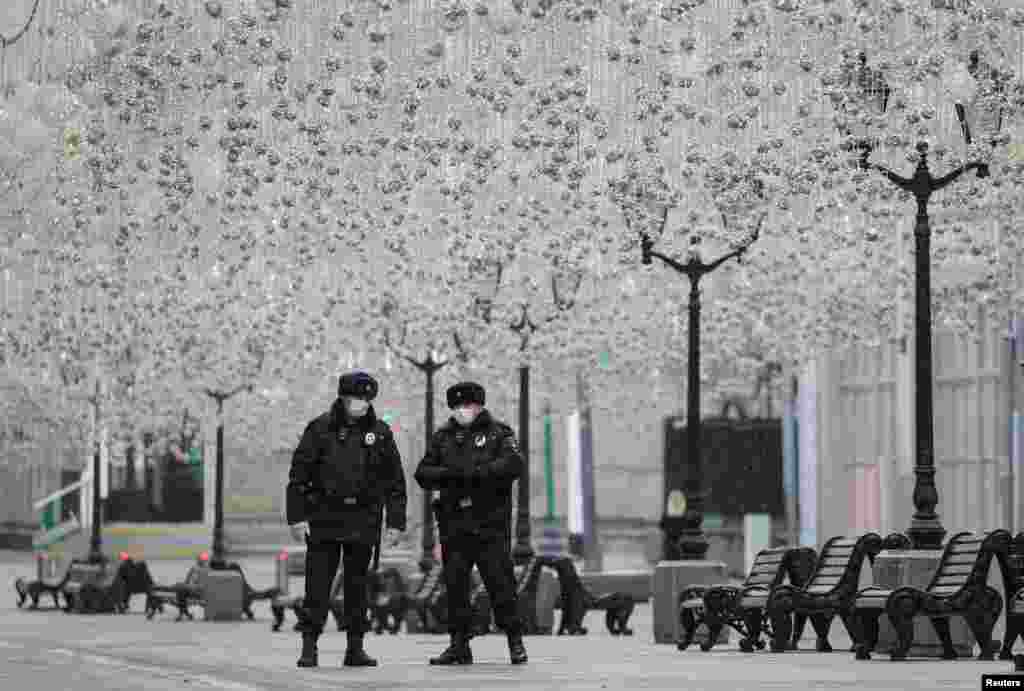 Russian law enforcement officers wearing protective masks stand guard in a street, after the city authorities announced a partial lockdown to prevent the spread of coronavirus disease (COVID-19), in central Moscow.