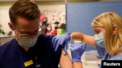 资料照片：印第安纳大学保健系统卫理公会医院的一名医学生为人接种新冠疫苗。 (2020年12月16日)