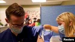 FILE - A medical student administers a COVID-19 vaccine at Indiana University Health, Methodist Hospital in Indianapolis, Indiana, Dec. 16, 2020.