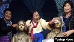 22일 제막식에 참석한 위안부 피해자 한국 이용수(88) 할머니가 소녀상의 얼굴을 닦아주고 있다.