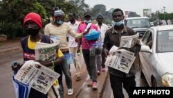 FILE: Street vendors sell newspapers showing articles about the elections on a street in Kampala, Uganda, on January 15, 2021. 