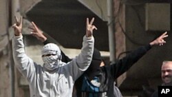 Anti-Syrian government protesters flash V-victory signs in the southern city of Daraa, March 23, 2011