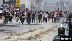 Supporters of Islamist group Ansar al-Sharia clash with riot police at Hai al-Tadamon in Tunis, May 19, 2013. 