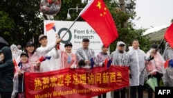 FIlE - Para pendukung berkumpul di jalan selama kunjungan Perdana Menteri China Li Qiang ke Institut Penelitian Tanaman dan Pangan Selandia Baru di Mt Albert, Auckland, 14 Juni 2024. (Brett Phibbs/AFP). 